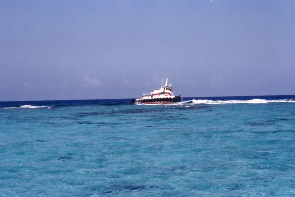 Rusting wrecked ship stranded on the shallow reef at Banco Chinchorro, Mexico