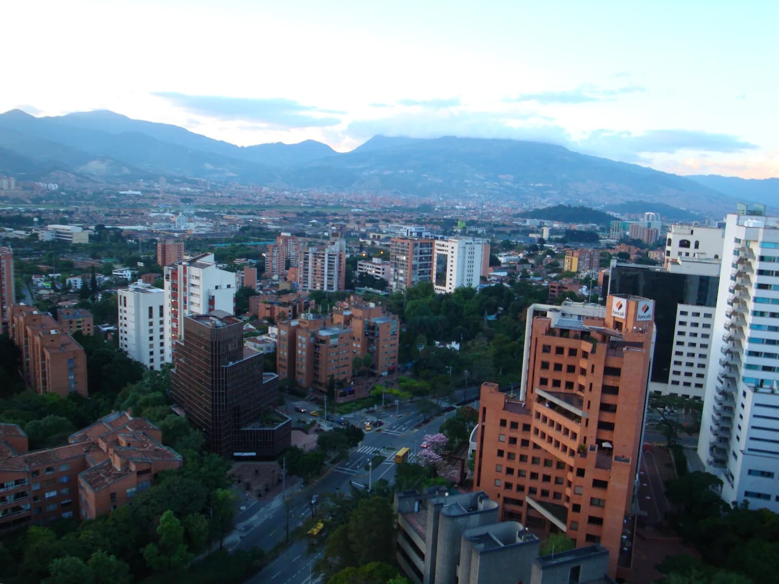 The city of Medellín filling a green valley with high-rise buildings under cloud