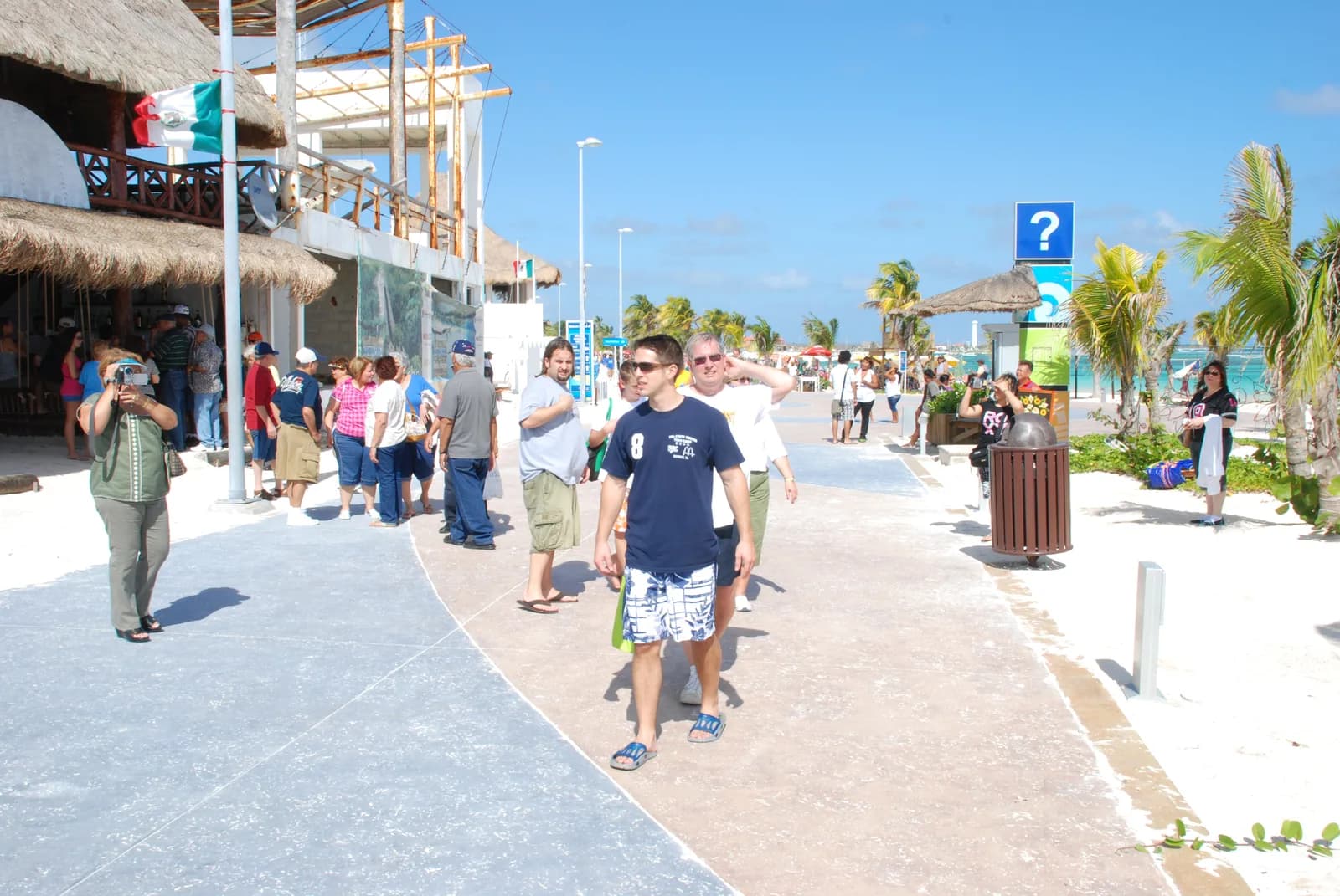 The car-free malecón boardwalk in Mahahual with palm trees and beachfront restaurants