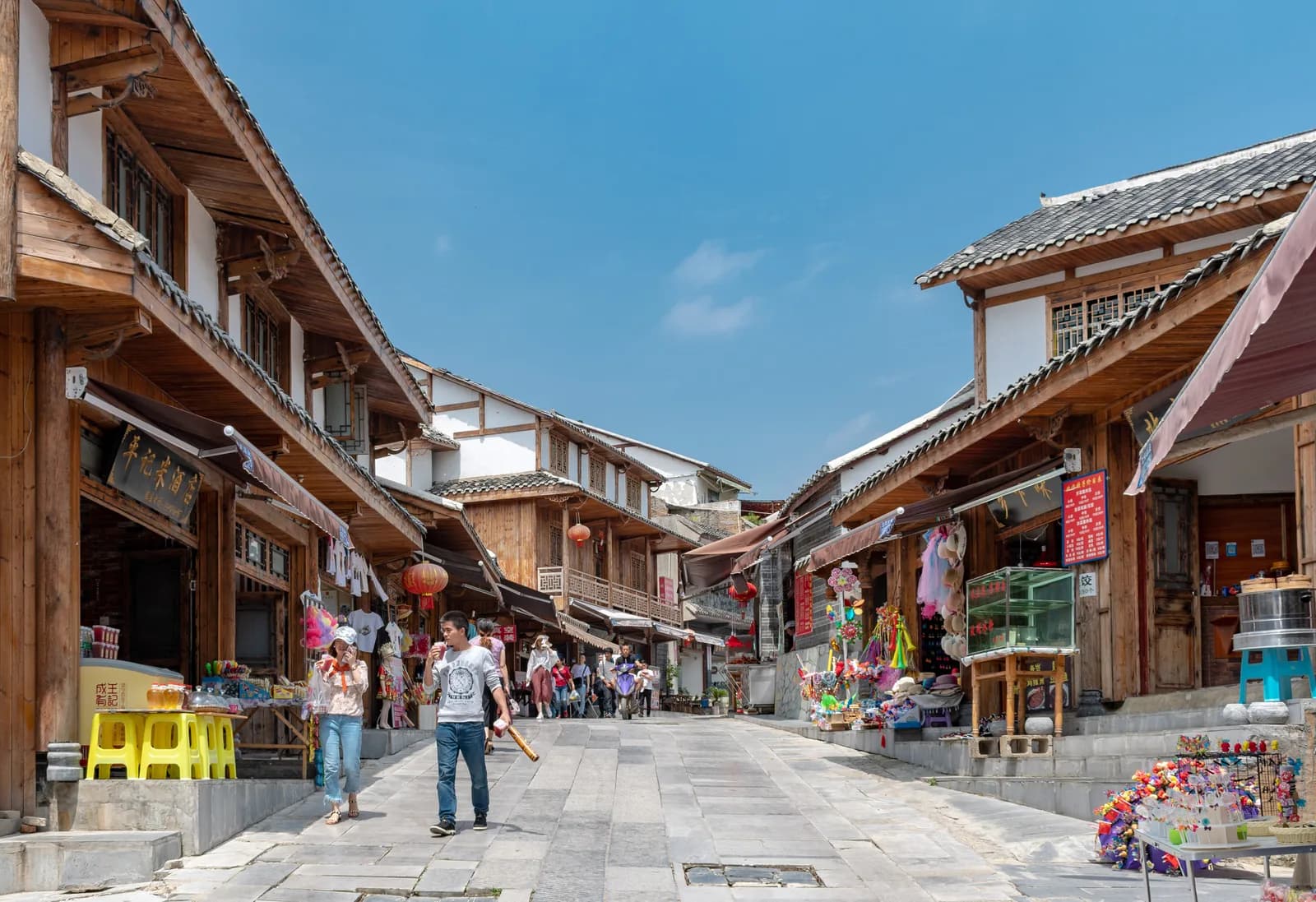 Stone-paved main street of Qingyan Ancient Town near Guiyang lined with timber shopfronts and grey-tiled roofs