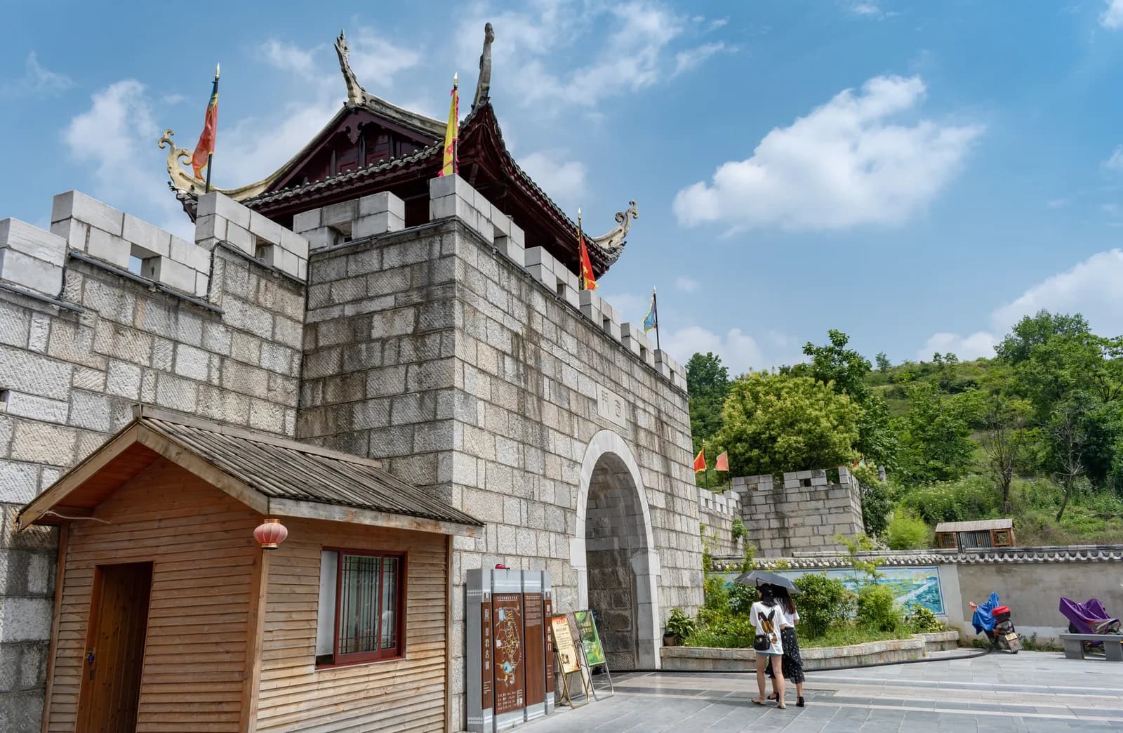 Stone city gate tower with a tiled roof and battlements on the Qingyan Ancient Town wall under a blue sky
