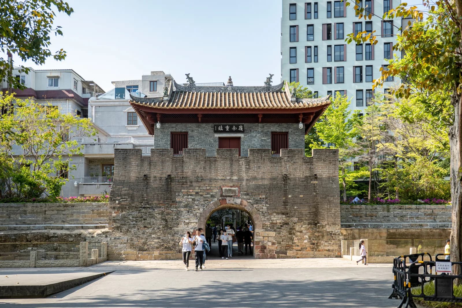 The restored south gate of Nantou Ancient City in Shenzhen with visitors walking through
