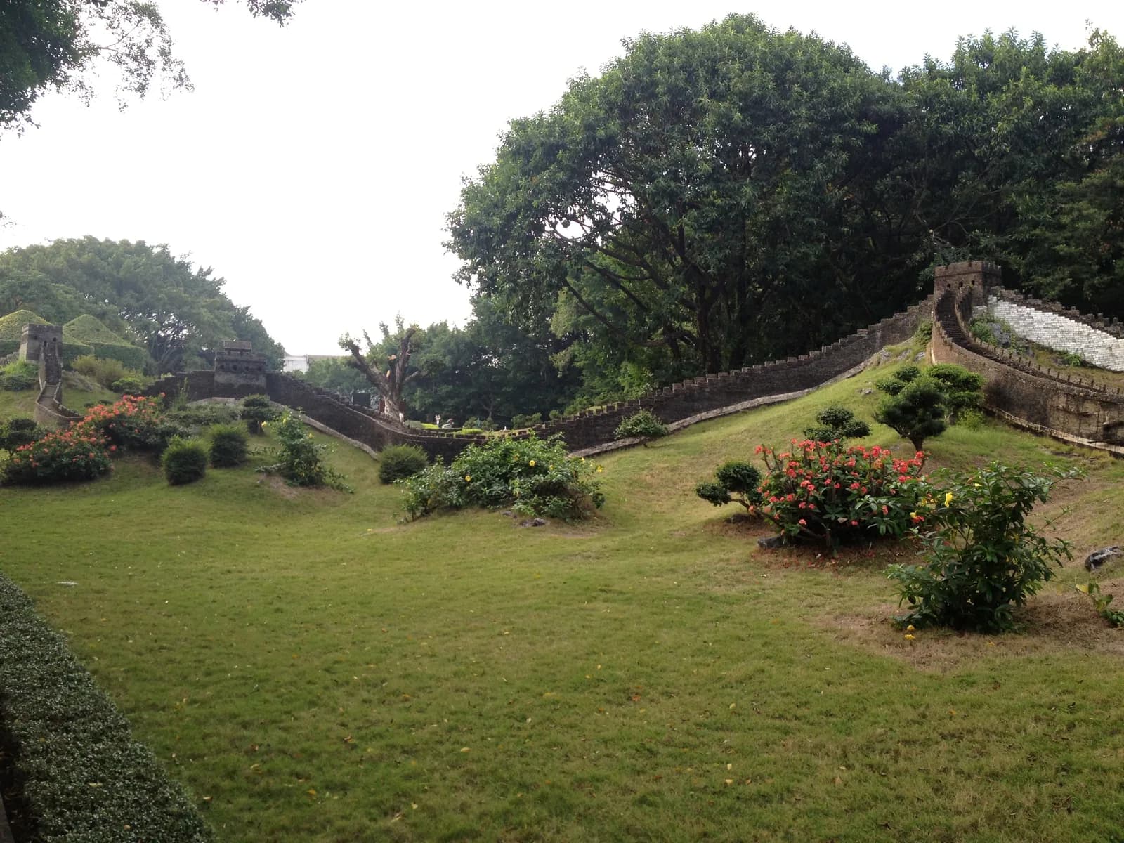 A scale model of the Great Wall of China winding over a green lawn at Splendid China in Shenzhen