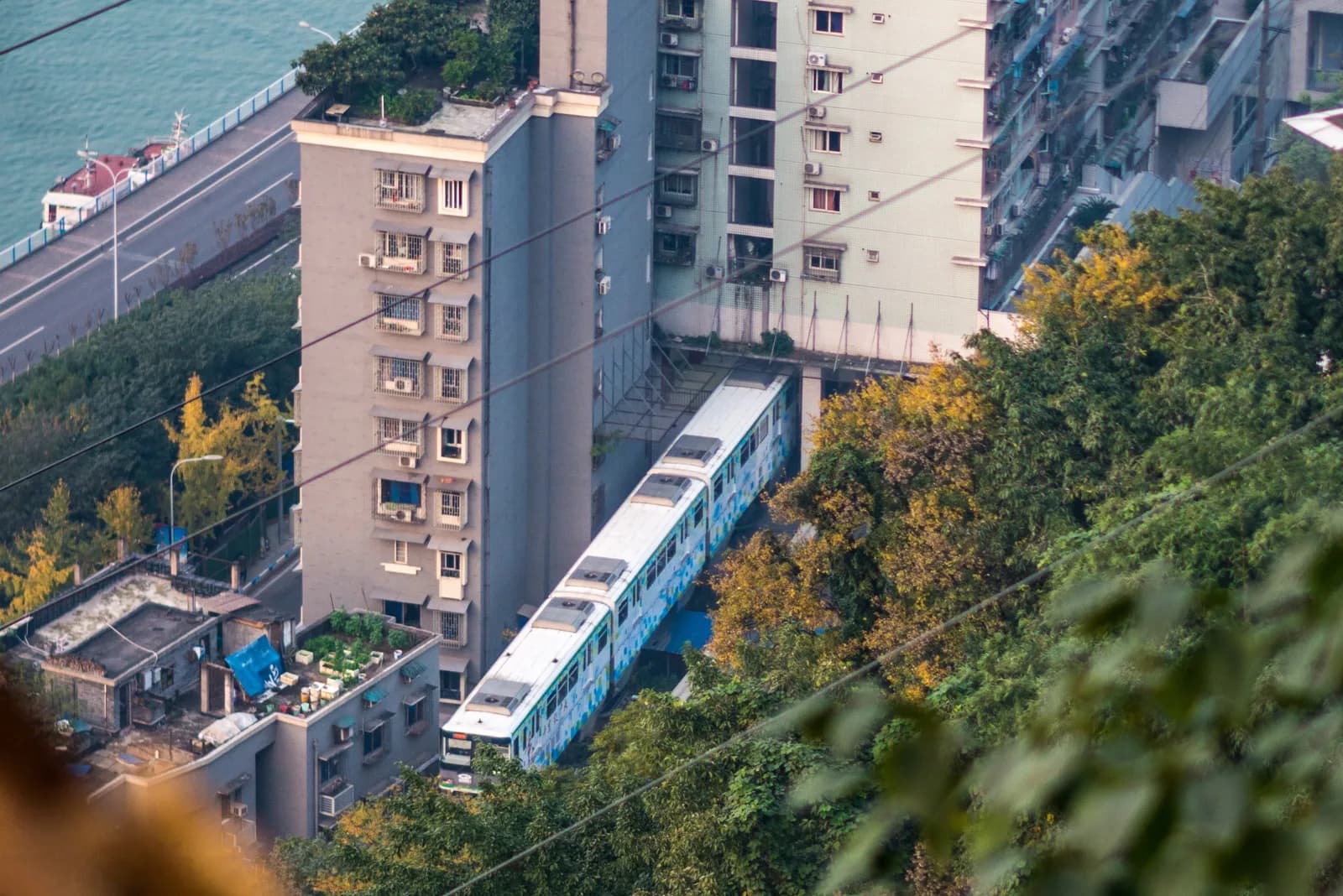 A Chongqing Rail Transit Line 2 monorail train passing through the middle of a residential building at Liziba station