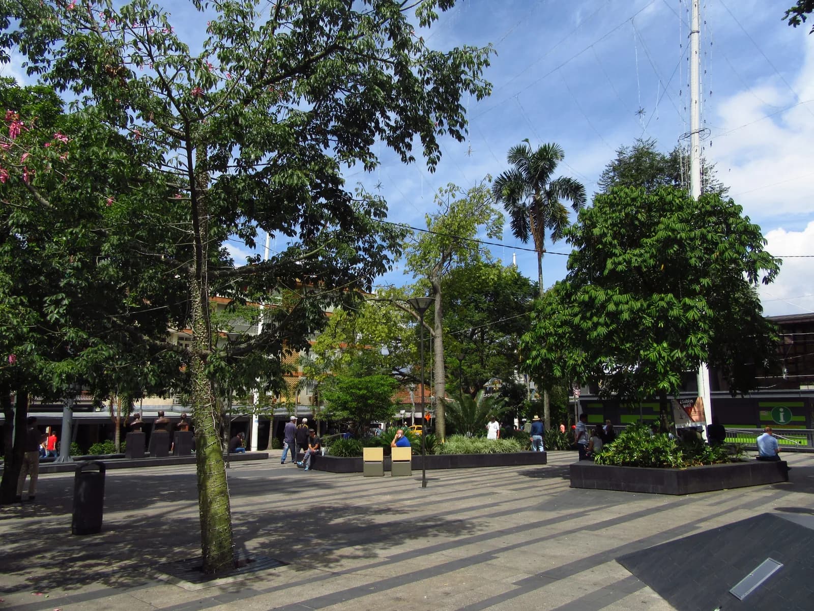 The tree-filled Parque Principal of Envigado with mid-rise buildings behind